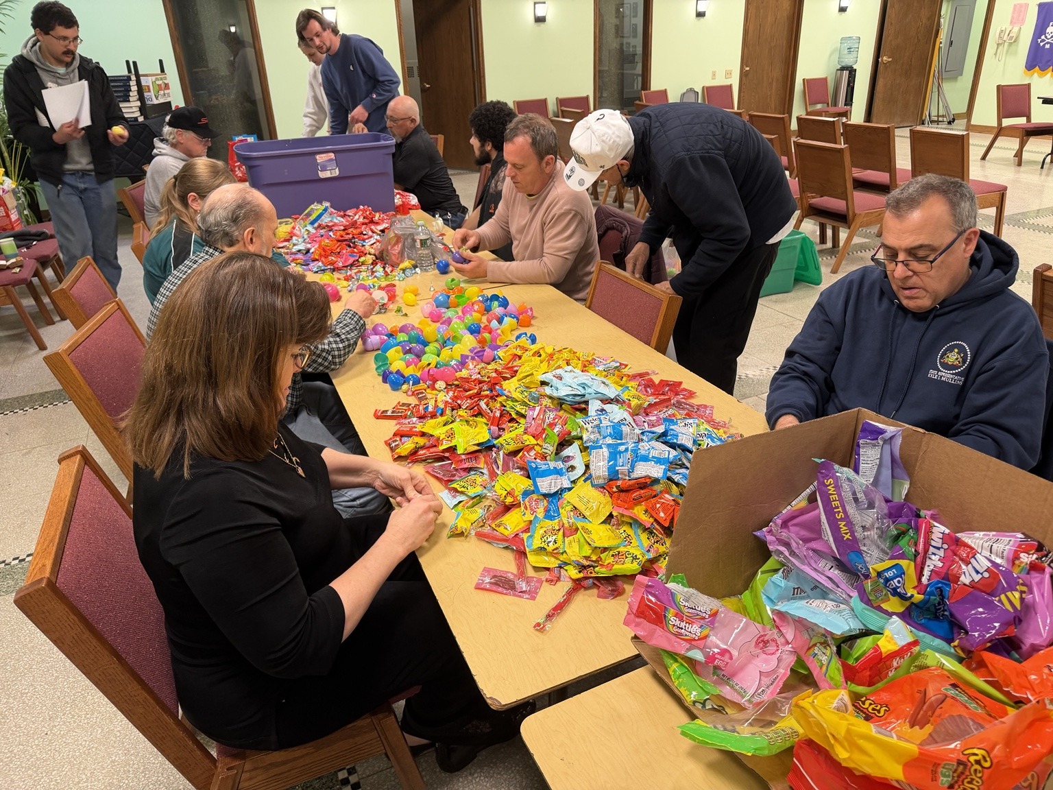 Volunteers work together to sort candy and fill Easter eggs for Buzzy Palooza.