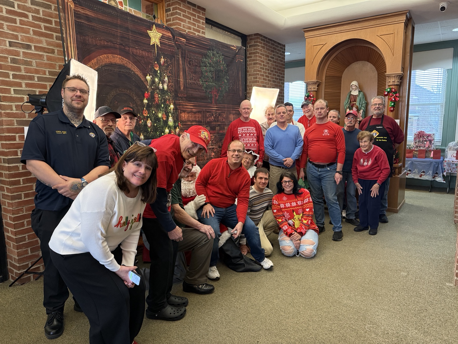 A group poses with Santa Claus beside Christmas decorations at Council 12572’s Breakfast with Santa on November 30, 2025.